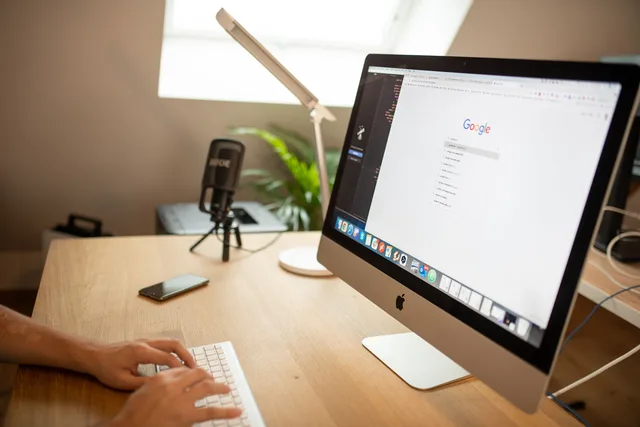 A modern workspace with an iMac displaying Google search, perfect for remote work setups. Teknisk SEO-tjekliste til danske hjemmesider